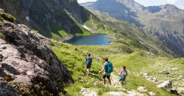 Drei Wanderer mit Wanderstöcken durch die Montafoner Alpenwelt.