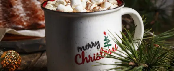 Eine Tasse mit der Aufschrift Merry Christmas und gefüllt mit Marshmallows